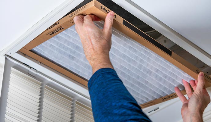 Technician replacing a new HVAC air filter