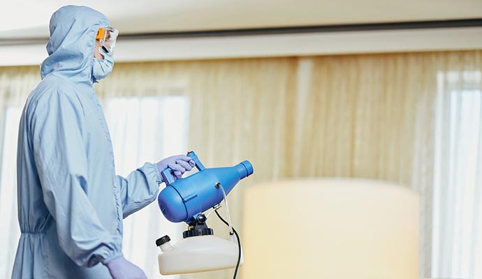 Technician using thermal fogging machine for smoke and odor decontamination process
