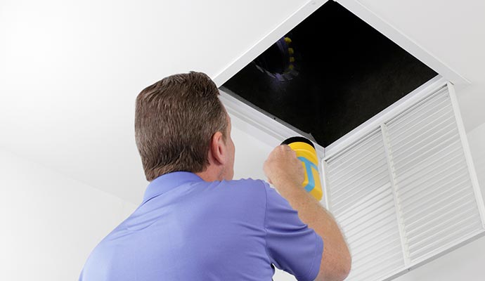 Technician inspecting air duct system