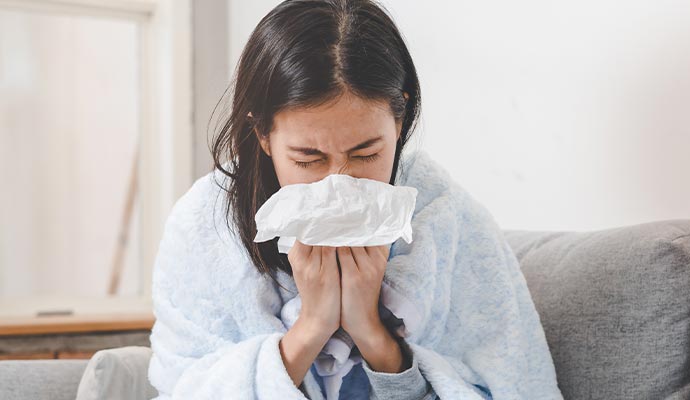 A woman sneezing due to dust or allergen issues
