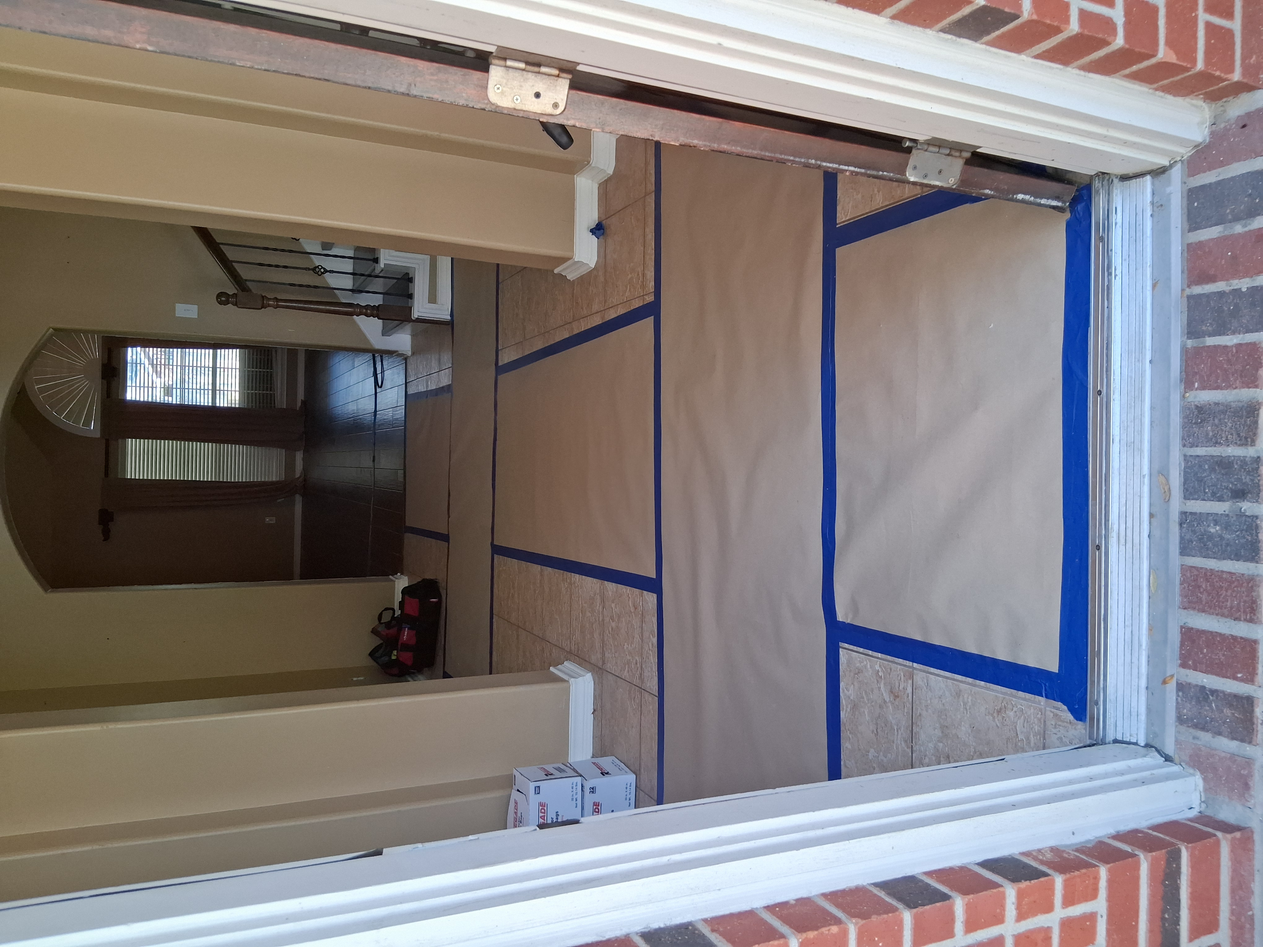 Hallway entrance showing protective paper and tape laid on the floor to prevent damage during water restoration services.