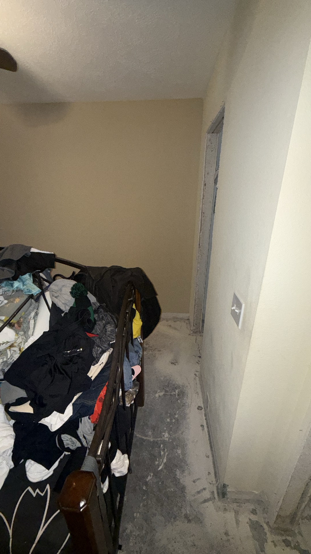 Bedroom with water damaged flooring removed, revealing concrete subfloor, ready for restoration