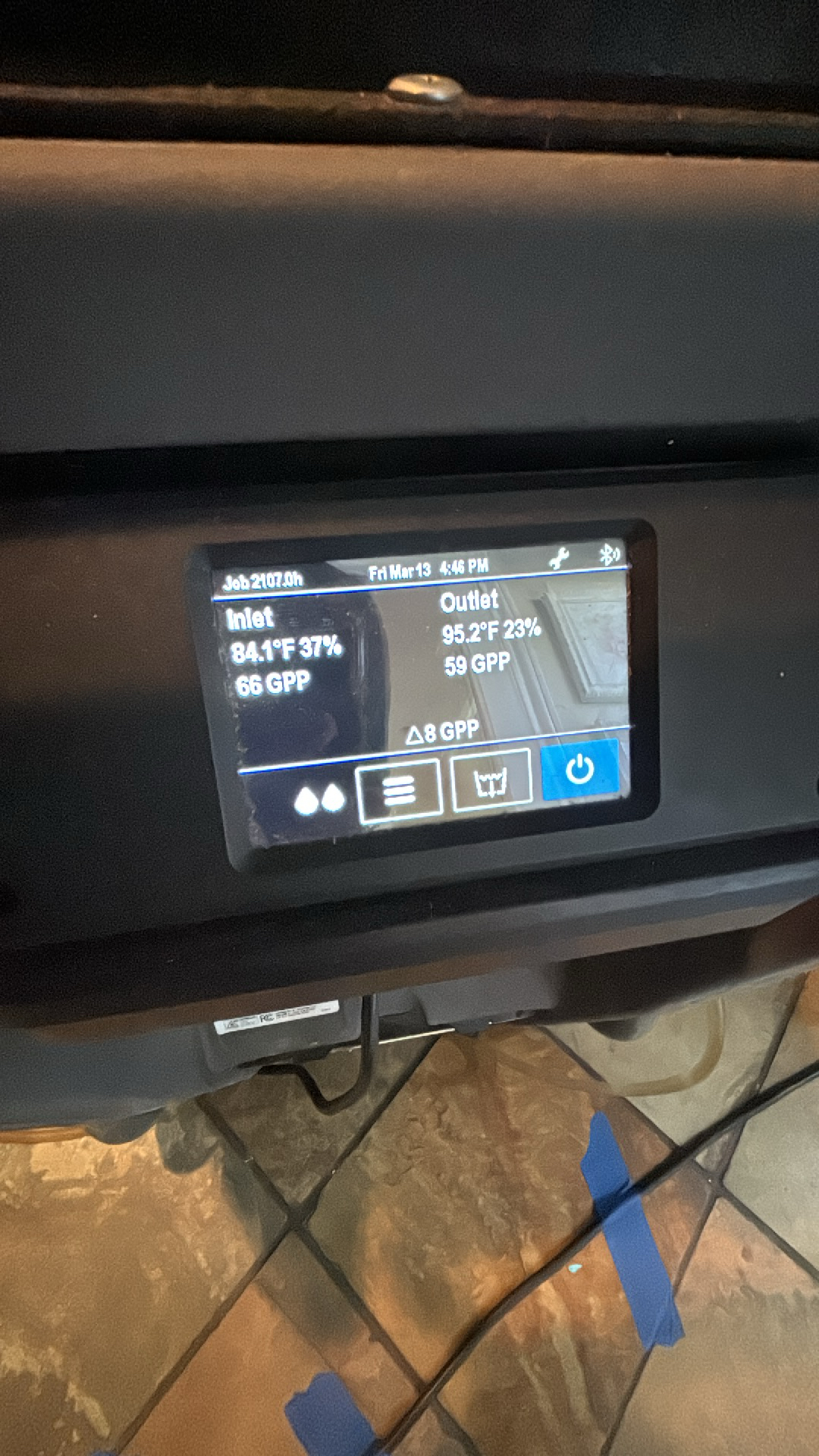 Dehumidifier control panel showing inlet and outlet temperature, humidity, and GPP readings, indicating active operation for water damage drying.